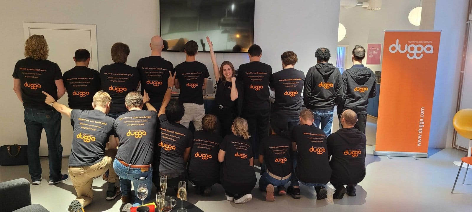 The Dugga team in black Dugga shirts in front of a Dugga banner