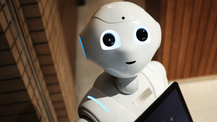 A white humanoid robot holding a tablet